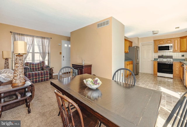 dining area with visible vents and light colored carpet