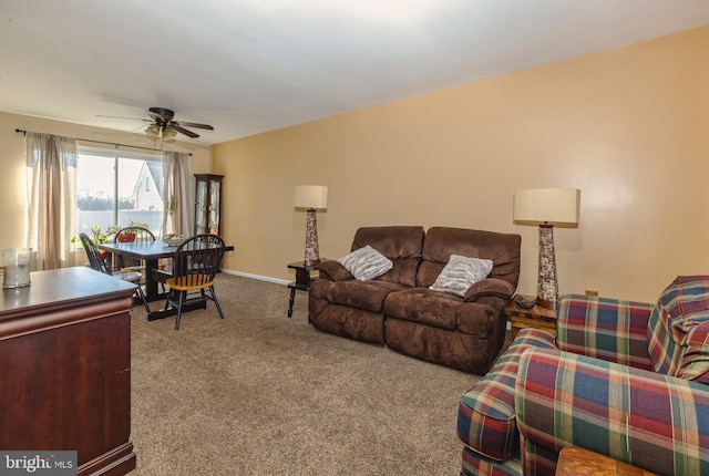 carpeted living room featuring a ceiling fan and baseboards