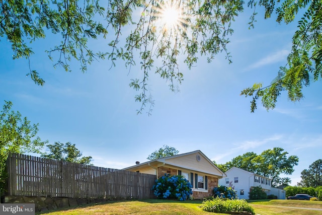 view of side of home with fence and a lawn