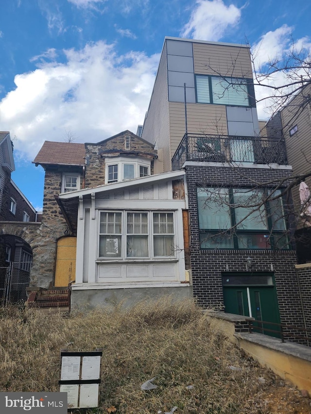 back of property featuring brick siding