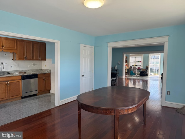 dining space featuring dark wood-style flooring and baseboards