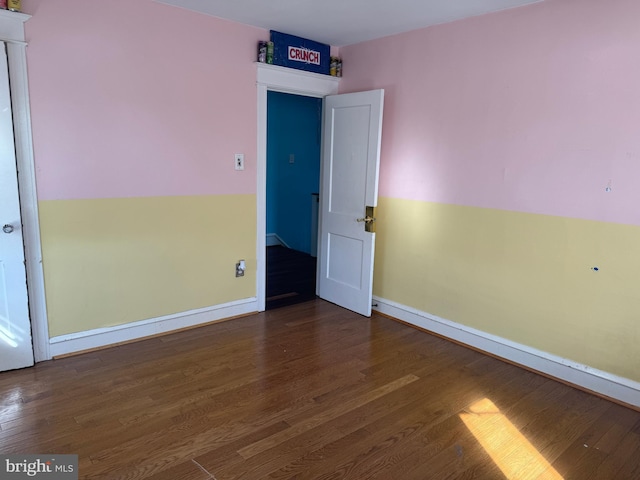 unfurnished room with wood finished floors and baseboards