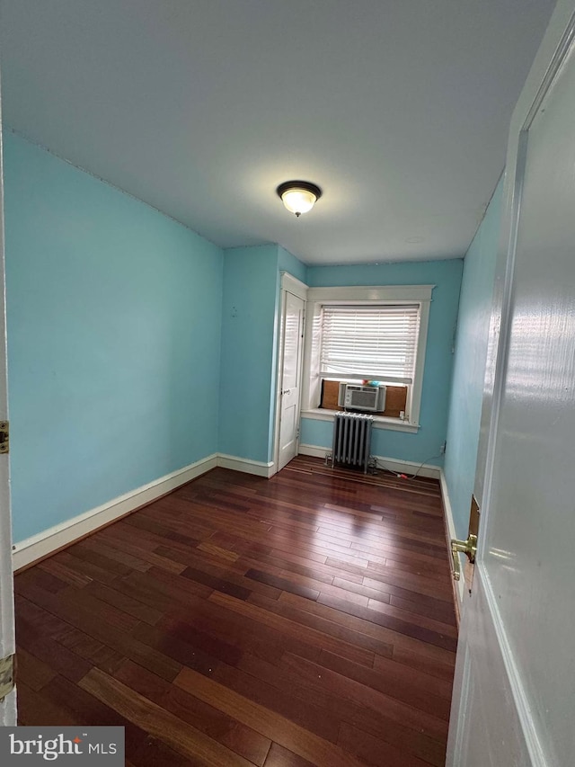 interior space with radiator, wood finished floors, and baseboards