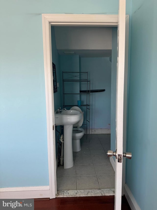 half bathroom featuring tile patterned flooring and baseboards