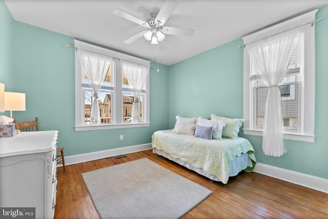 bedroom featuring ceiling fan, hardwood / wood-style floors, and baseboards