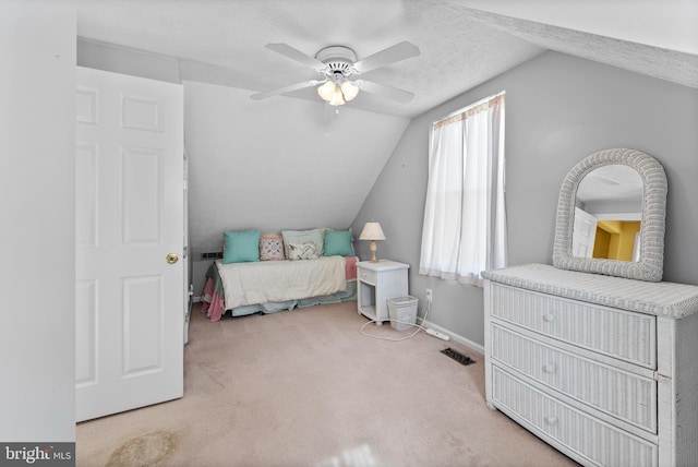 bedroom with a textured ceiling, carpet floors, visible vents, baseboards, and vaulted ceiling