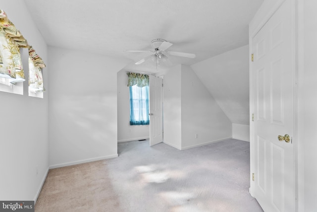 additional living space with ceiling fan, carpet, baseboards, and vaulted ceiling