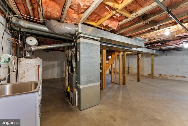 unfinished basement with water heater and heating unit