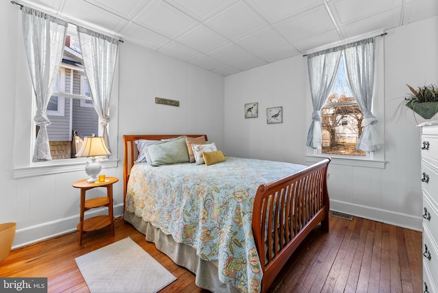 bedroom with baseboards, visible vents, and hardwood / wood-style floors