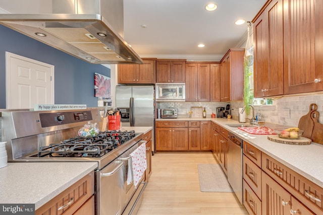 kitchen with a sink, light countertops, appliances with stainless steel finishes, backsplash, and range hood