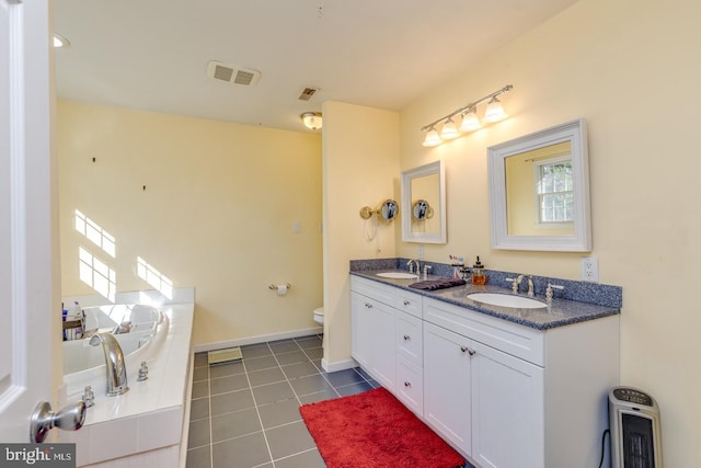 bathroom featuring double vanity, visible vents, a sink, and tile patterned floors