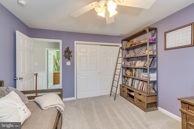 bedroom with light carpet, ceiling fan, baseboards, and a closet