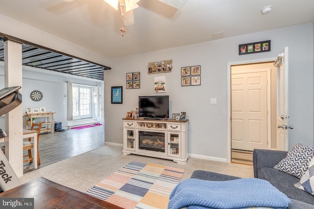 living room featuring light colored carpet and baseboards