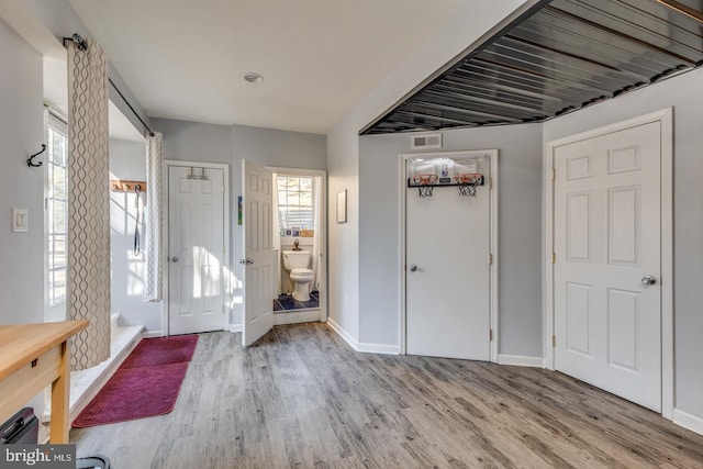 entrance foyer featuring visible vents, baseboards, and wood finished floors