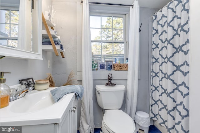 bathroom featuring curtained shower, vanity, toilet, and a healthy amount of sunlight