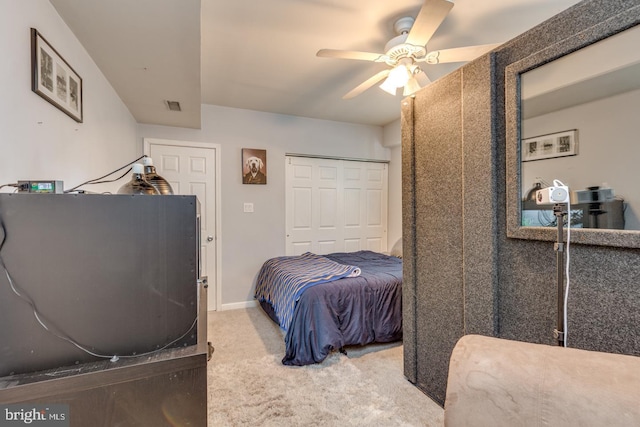 carpeted bedroom with baseboards, a closet, visible vents, and a ceiling fan