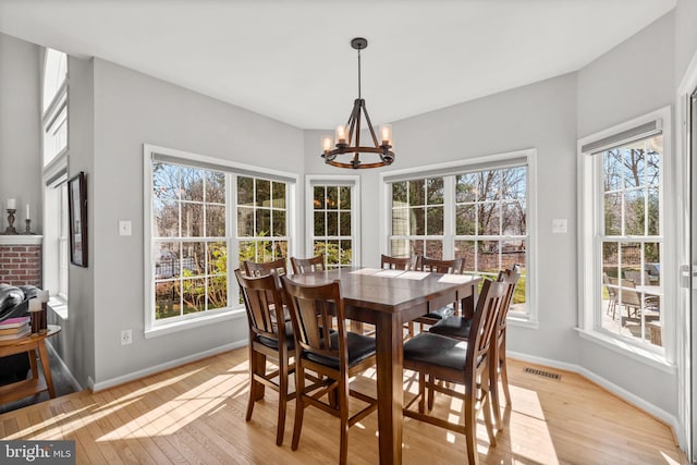 dining space featuring light wood-type flooring, visible vents, plenty of natural light, and a chandelier