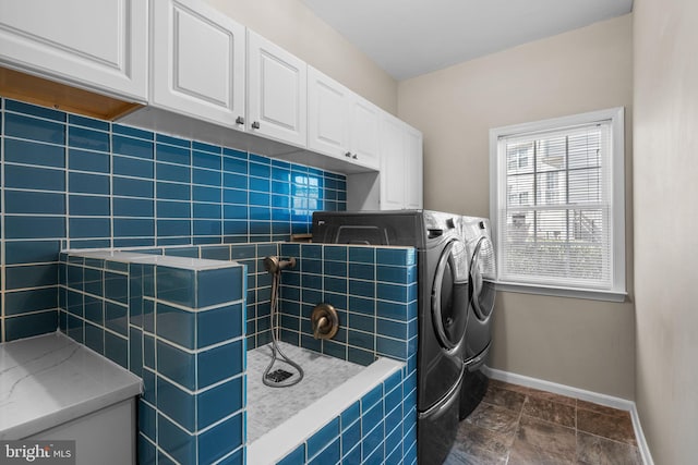 laundry area featuring baseboards, cabinet space, and independent washer and dryer