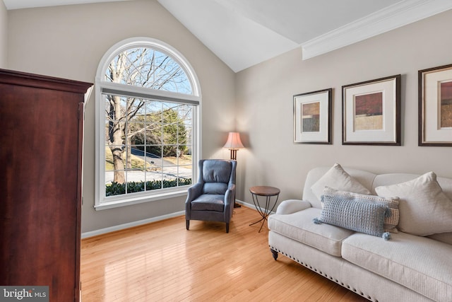 living area featuring vaulted ceiling, wood-type flooring, baseboards, and a wealth of natural light