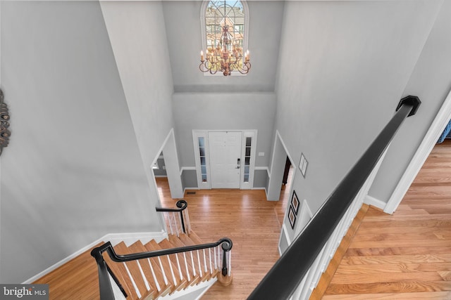 entryway featuring stairway, a high ceiling, wood finished floors, and baseboards