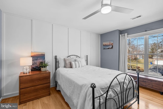 bedroom with a ceiling fan, light wood-style floors, and visible vents