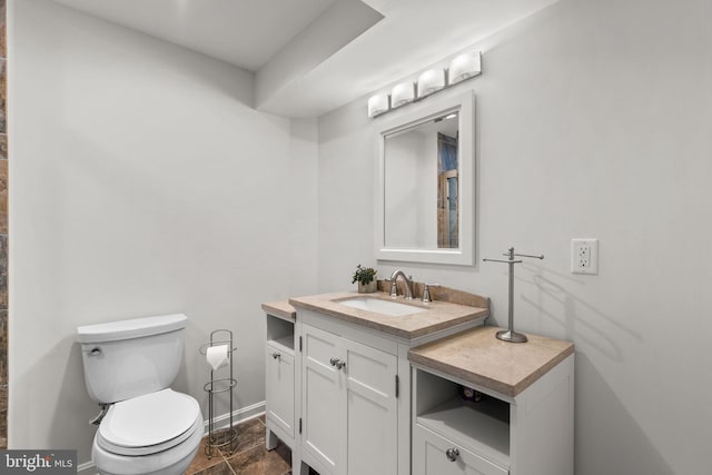 bathroom featuring baseboards, toilet, and vanity