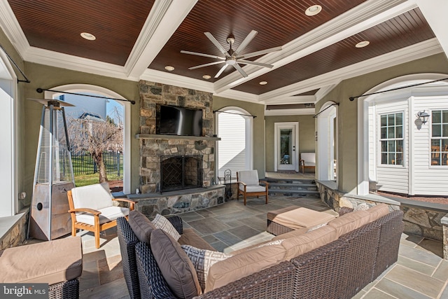 view of patio with an outdoor living space with a fireplace, a ceiling fan, and fence