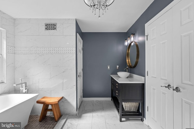 full bath with visible vents, baseboards, a soaking tub, marble finish floor, and vanity