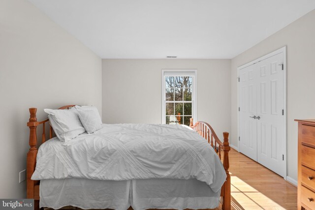 bedroom featuring visible vents, light wood-type flooring, and baseboards