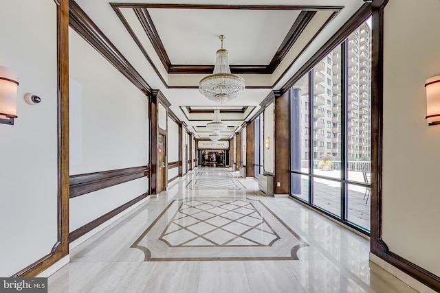 hall featuring a chandelier, marble finish floor, crown molding, and baseboards