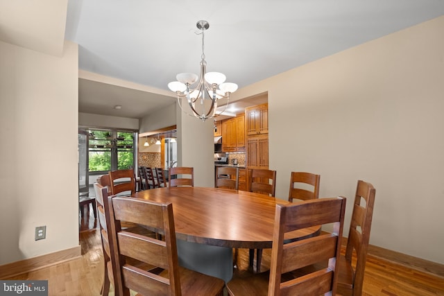5724 4th St NW, Washington, DC 20011 - dining area featuring a chandelier, light wood-style floors, and baseboards