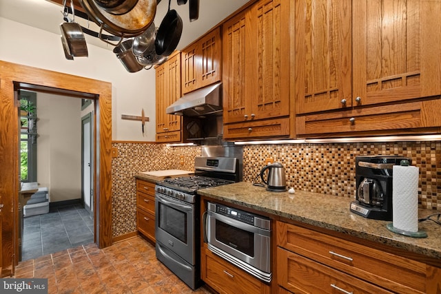 5724 4th St NW, Washington, DC 20011 - kitchen featuring under cabinet range hood, stainless steel gas range, brown cabinets, stone counters, and backsplash