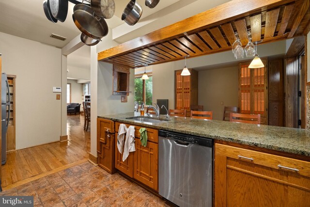 5724 4th St NW, Washington, DC 20011 - kitchen featuring stainless steel dishwasher, a sink, brown cabinets, hanging light fixtures, and stone counters