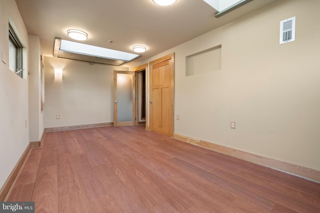 5724 4th St NW, Washington, DC 20011 - unfurnished room with light wood-style flooring, a skylight, and baseboards