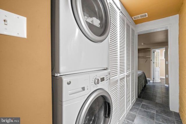 5724 4th St NW, Washington, DC 20011 - washroom featuring stacked washer / drying machine and dark tile patterned floors