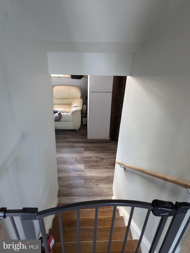 stairway featuring baseboards and wood finished floors