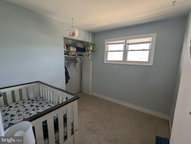 carpeted bedroom with a closet and baseboards