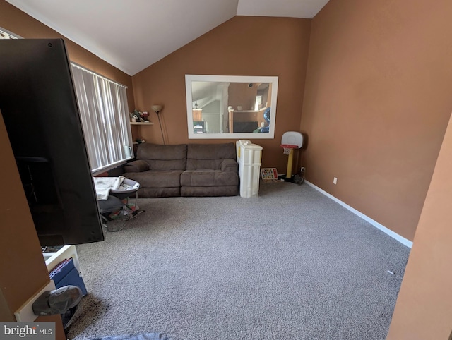 interior space featuring lofted ceiling, carpet flooring, and baseboards