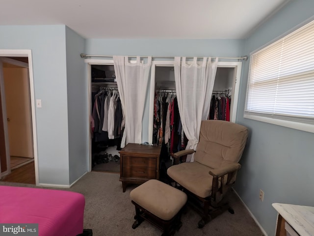 carpeted bedroom with baseboards and two closets