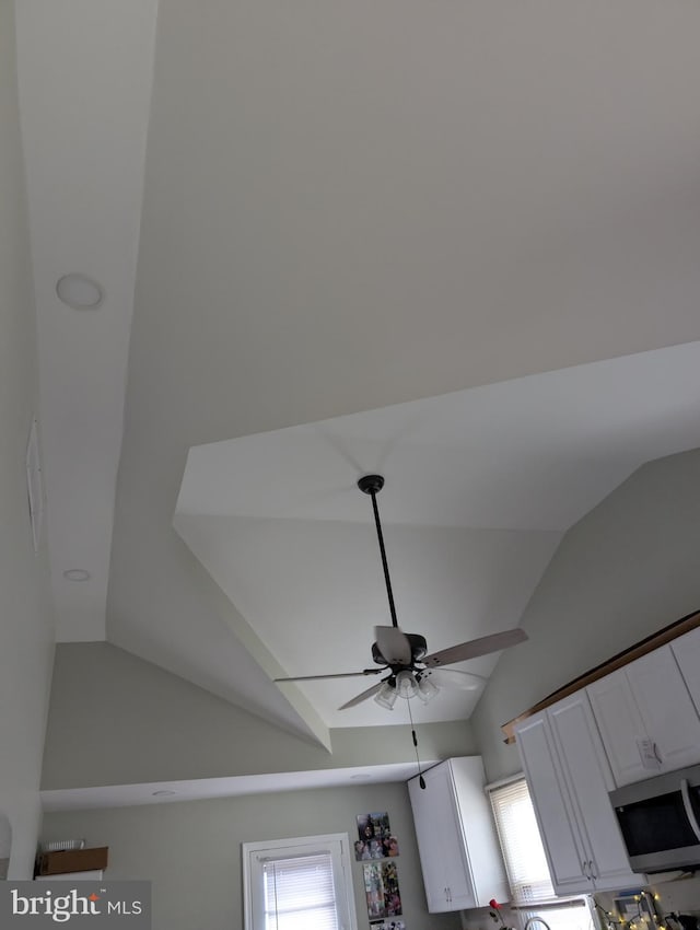 room details with stainless steel microwave, a ceiling fan, and white cabinetry