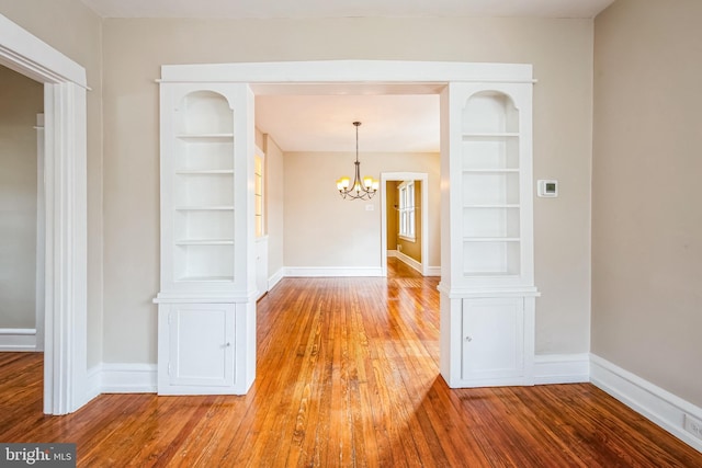 interior space featuring baseboards, wood-type flooring, and built in features