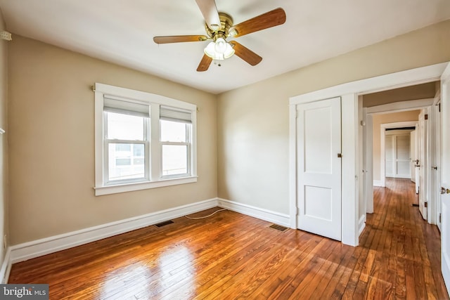 unfurnished bedroom featuring visible vents, baseboards, and hardwood / wood-style flooring