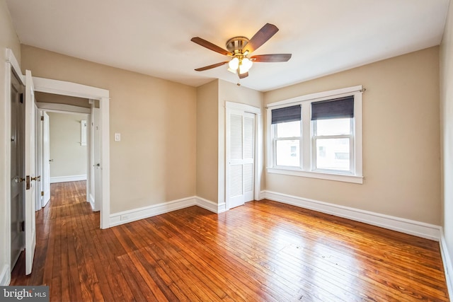 unfurnished bedroom with wood-type flooring, baseboards, ceiling fan, and a closet