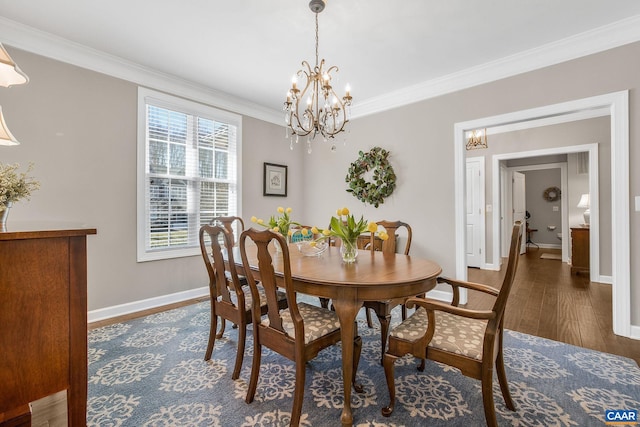 dining area with an inviting chandelier, baseboards, ornamental molding, and wood finished floors