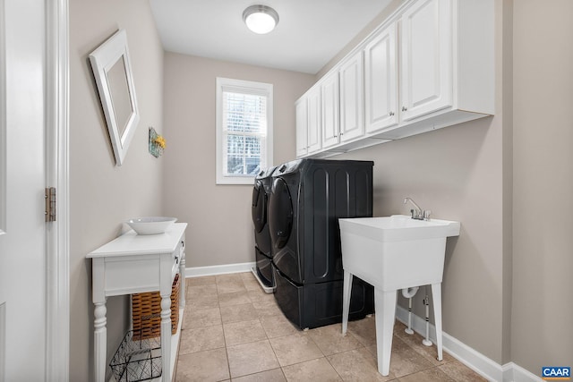 washroom featuring light tile patterned floors, cabinet space, baseboards, and separate washer and dryer