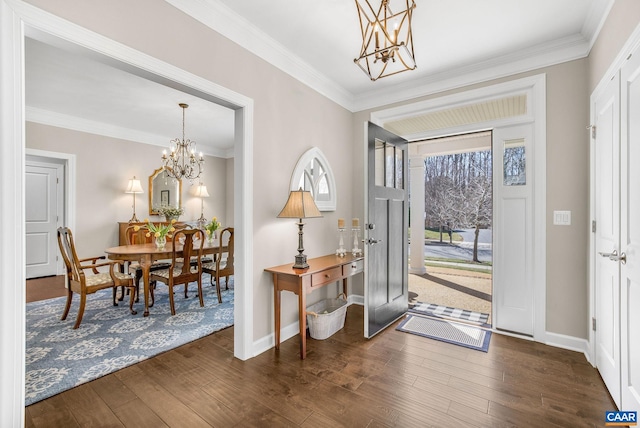 entrance foyer with a chandelier, dark wood-type flooring, and crown molding