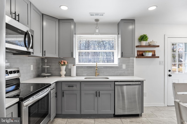 kitchen featuring a sink, visible vents, light countertops, appliances with stainless steel finishes, and gray cabinets