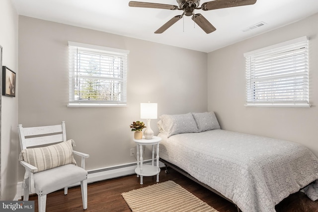 bedroom featuring ceiling fan, a baseboard radiator, wood finished floors, and visible vents