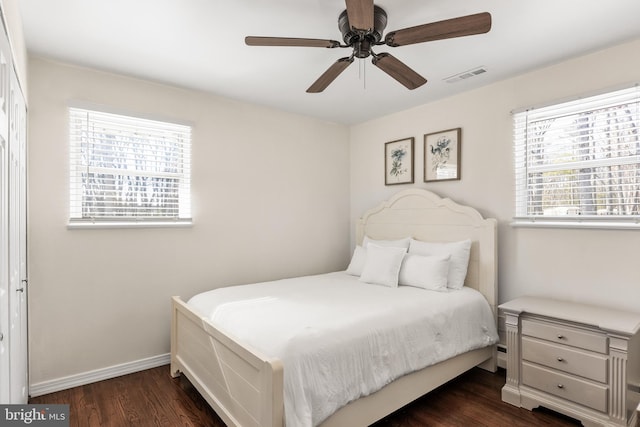 bedroom featuring a ceiling fan, visible vents, dark wood finished floors, and baseboards