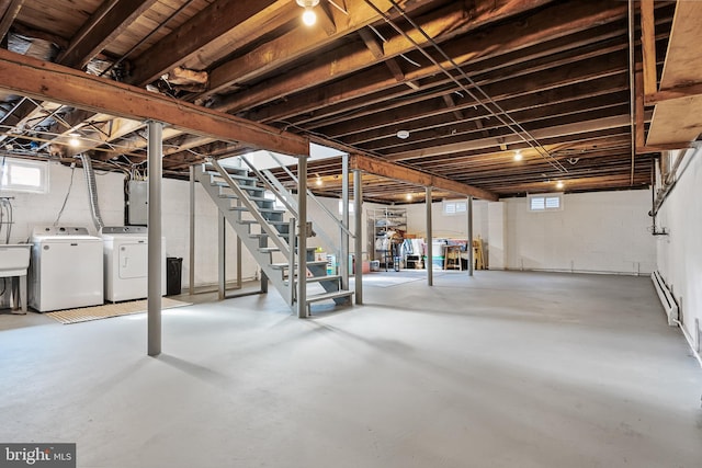 basement with a wealth of natural light, electric panel, washer and clothes dryer, and stairs